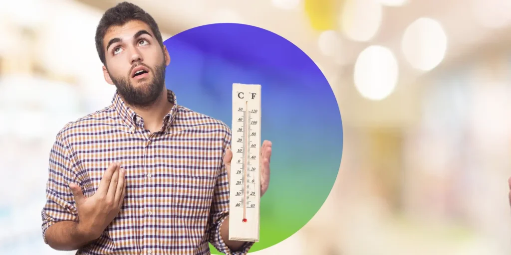 man holding a thermometer in hot weather
