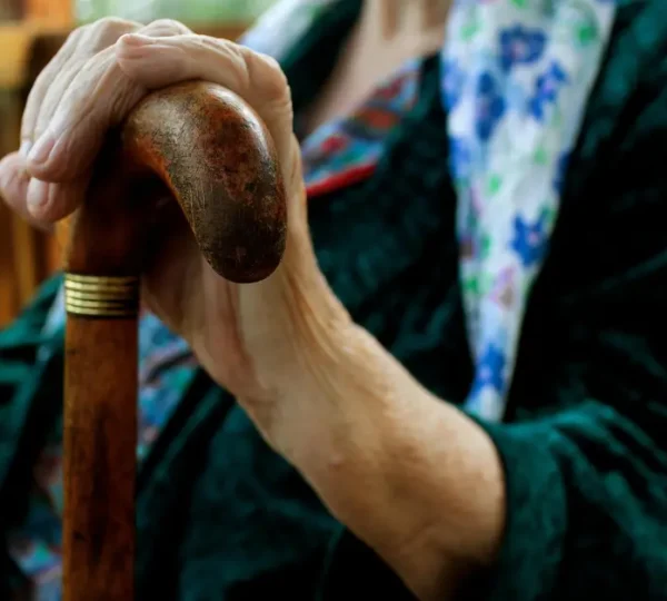 A caregiver assisting an elderly person in a calm and respectful home setting, reflecting quality elder care services in Dubai.