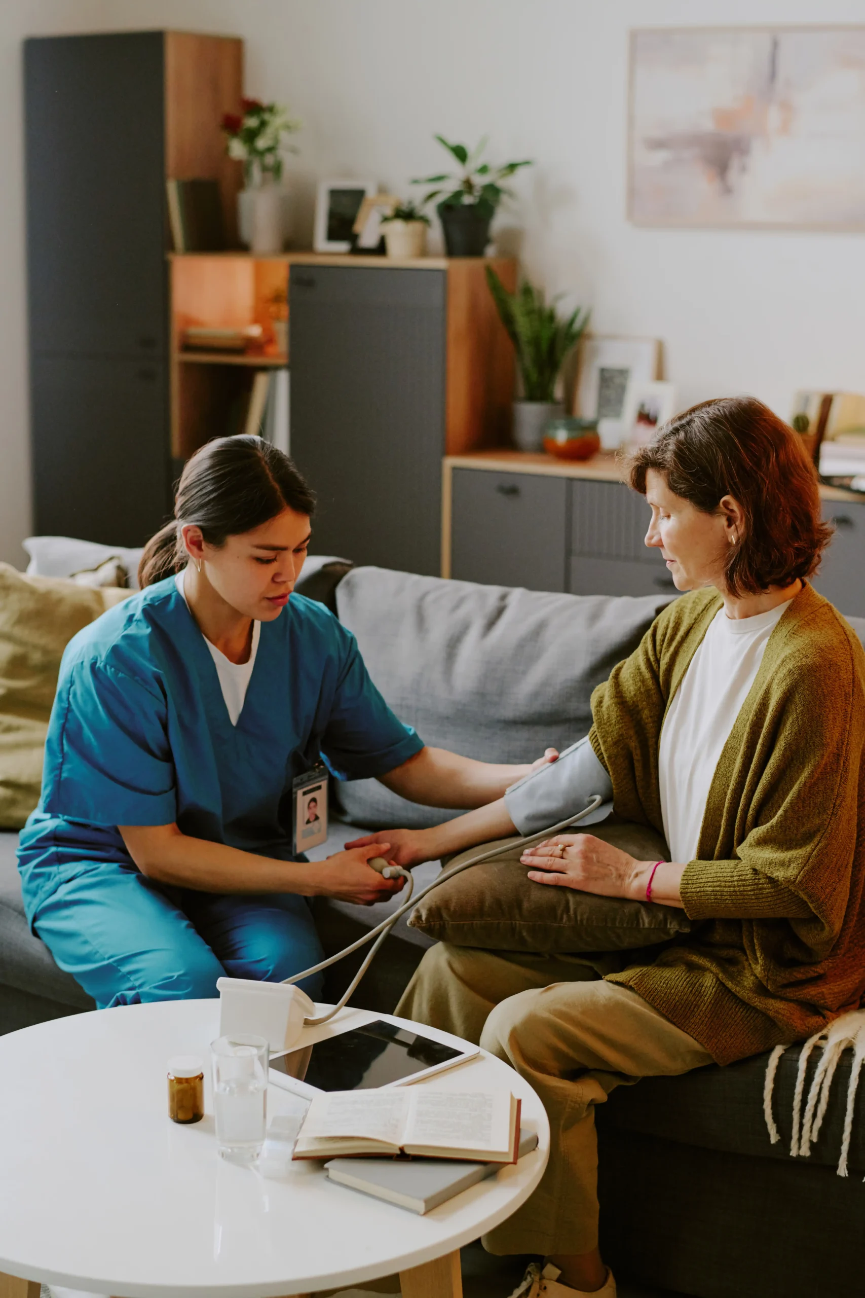 A home nurse performing a blood pressure check on a patient, delivering quality home health care services in Dubai