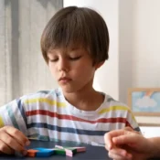 A home nurse is helping an autistic kid with activities