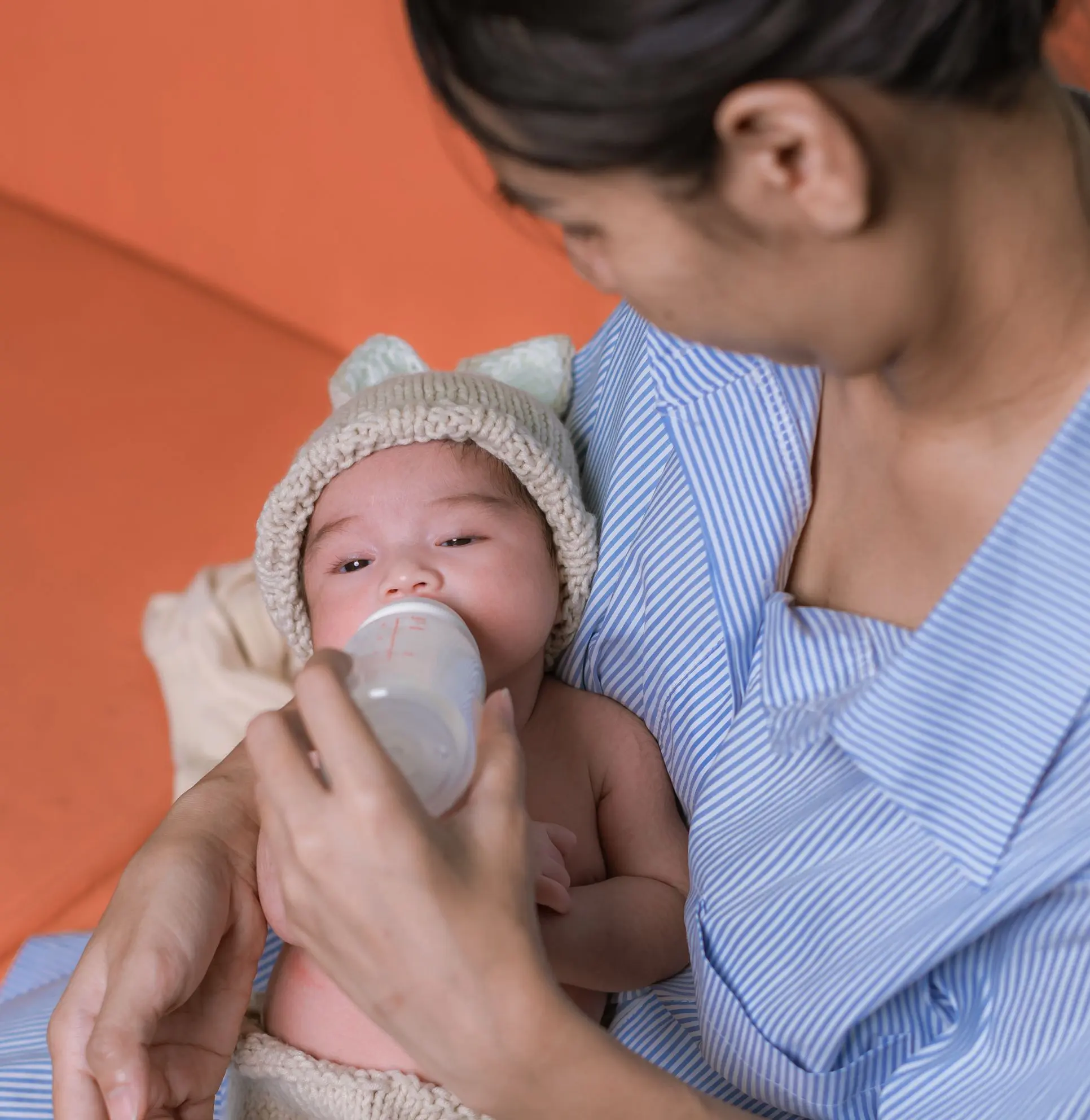 A nurse providing newborn care by feeding a baby in Dubai, demonstrating professional home healthcare services